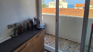 A kitchen with a coffee maker, jars, and a tiled backsplash. - New, bright 2-room apartment with ocean views and direct access to the beaches, near Menton and Monaco (Roquebrune-Cap-Martin)