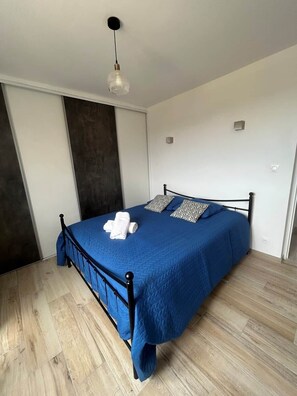A bedroom with a bed, a hanging light fixture, and a dark accent wall. - "La Parenthèse de Caminade" on the outskirts of Sarlat (Sarlat-la-Canéda)