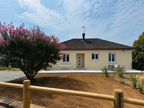 A single-story building with a tiled roof, a front door, and a bench outside. - "La Parenthèse de Caminade" on the outskirts of Sarlat (Sarlat-la-Canéda)