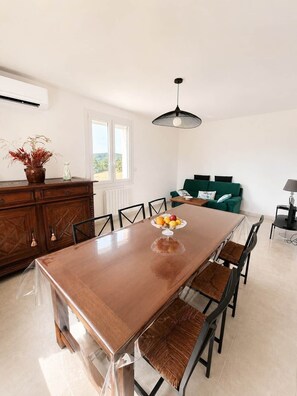 A spacious dining area with a long table, chairs, and a fruit bowl centerpiece. - "La Parenthèse de Caminade" on the outskirts of Sarlat (Sarlat-la-Canéda)