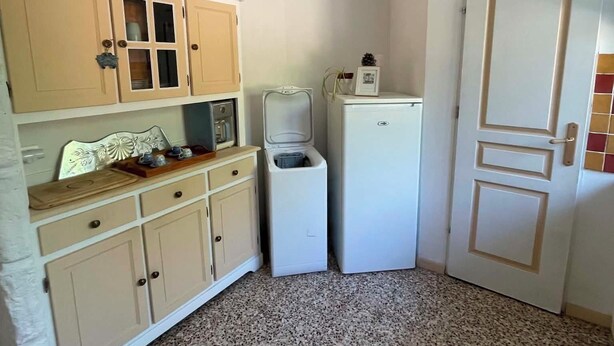 Eine kleine Küche mit Mikrowelle, Kühlschrank und Spüle.