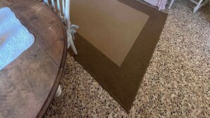 Ein Wohnzimmer mit einer Couch, einem Couchtisch, einem Fernseher und einem Gemälde an der Wand.