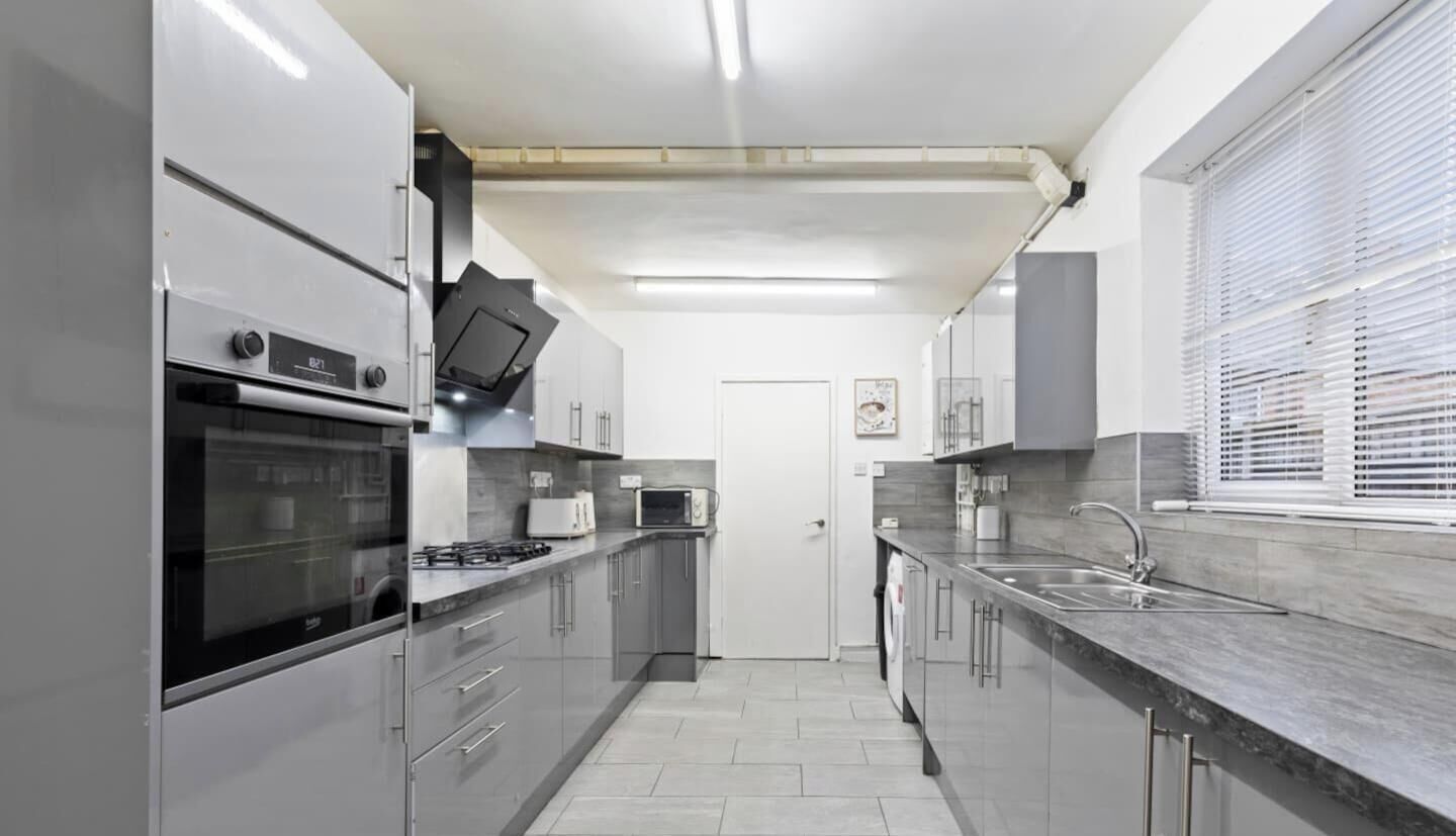 A modern kitchen with stainless steel appliances, a built-in oven, a microwave, and a sink.