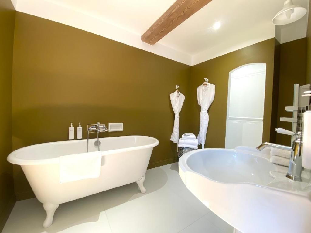 Un baño con una bañera independiente, un lavamanos grande y un espejo.