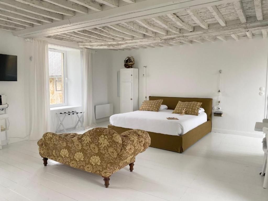 Un dormitorio con cama, un banco de madera, un armario y un televisor.