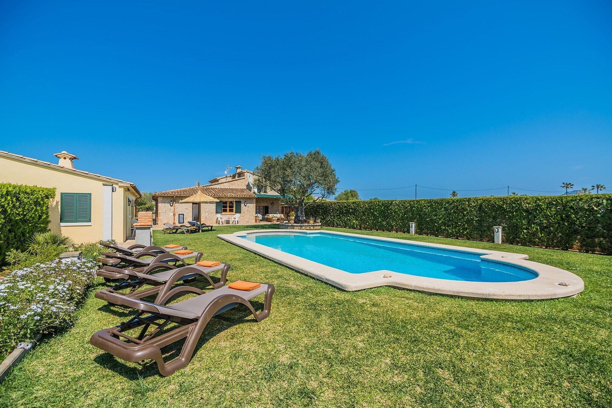 A swimming pool with lounge chairs and a building in the background.