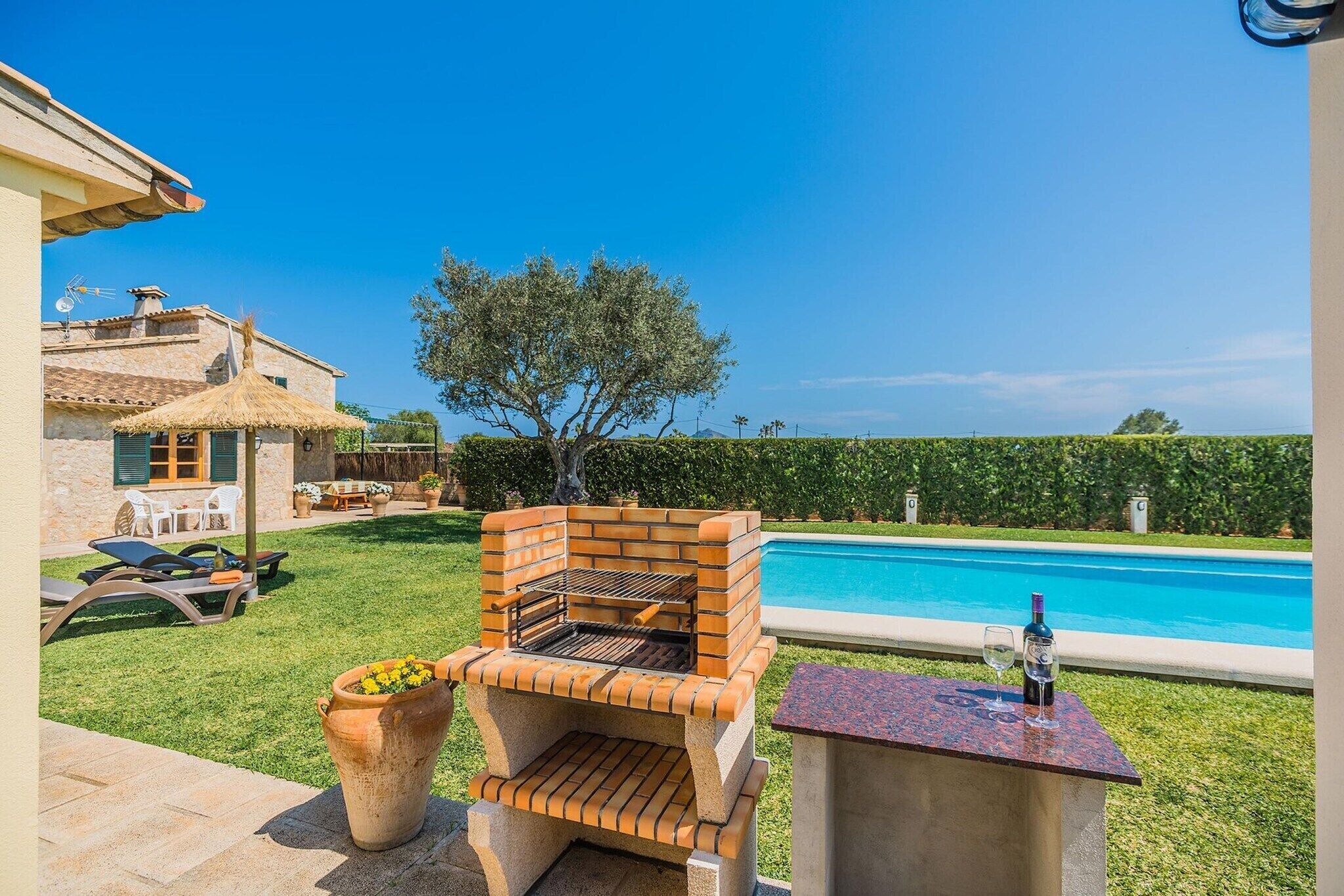 Patio con una parrilla, piscina y mobiliario exterior.