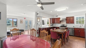 A spacious kitchen with a dining area, wooden cabinets, and a ceiling fan. - 5 BR 5 Bath Home Bay side 10 people 2 Car parking (Seaside Heights)