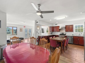 A spacious kitchen with a dining area, wooden cabinets, and a ceiling fan. - 5 BR 5 Bath Home Bay side 10 people 2 Car parking (Seaside Heights)