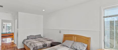 Ein Schlafzimmer mit zwei Betten, einem Deckenventilator und einem Fenster.