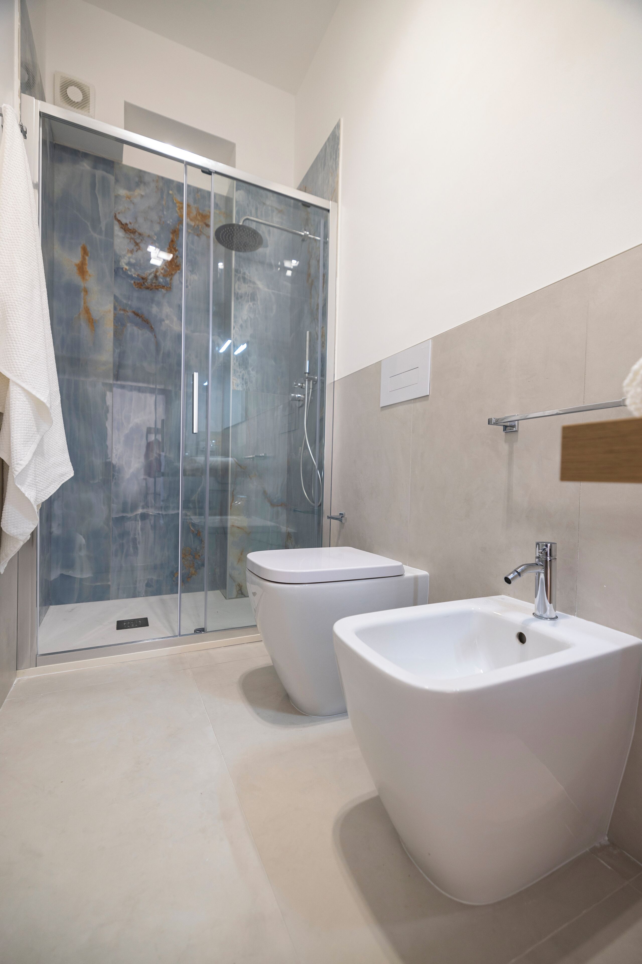A modern bathroom with a glass-enclosed shower, a standalone bathtub, and a separate sink.