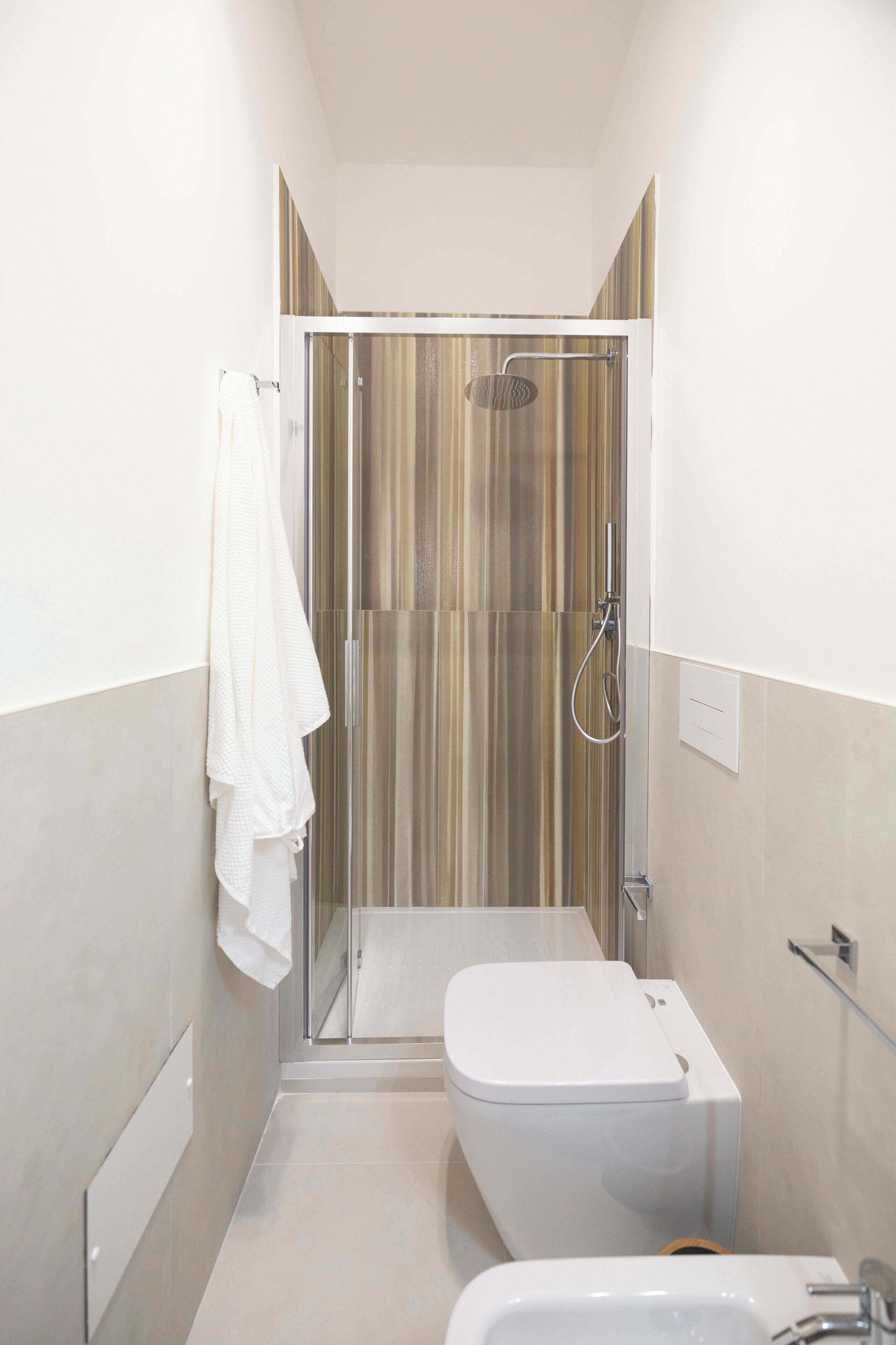 Un baño moderno con ducha envuelta en vidrio, inodoro blanco y bañera.