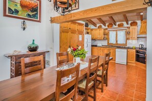 Ein Holzespeisesaal mit Stühlen, einer Blumenvase und einem Bild an der Wand.