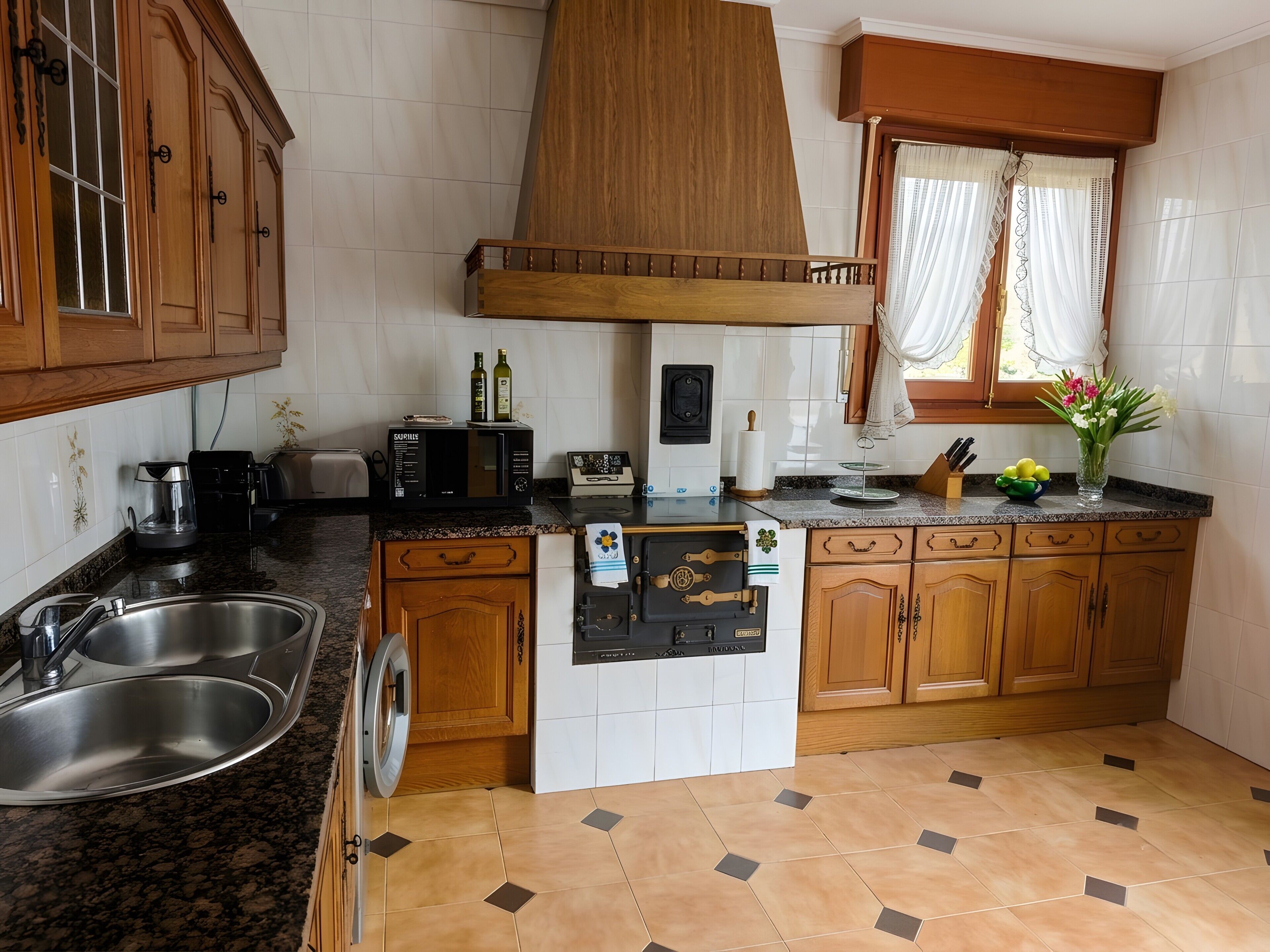 A kitchen with wooden cabinets, a stainless steel sink, a microwave, and a refrigerator.
