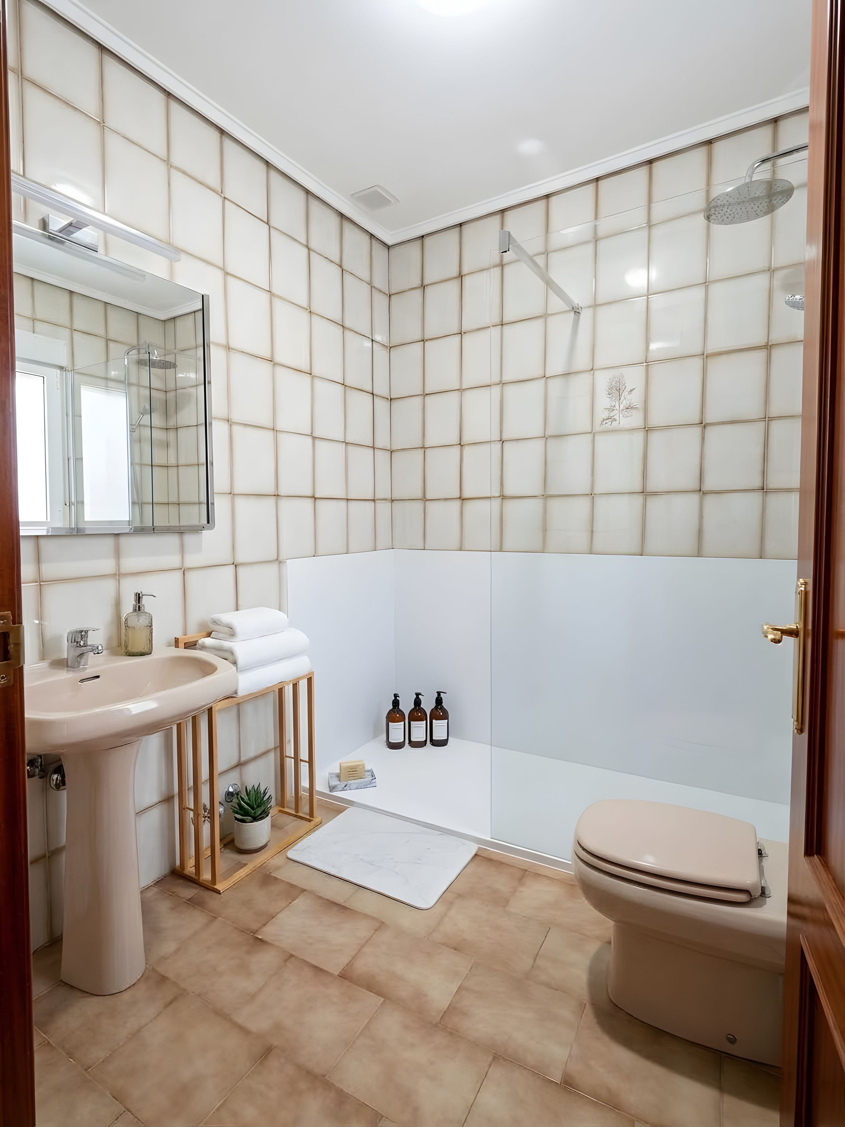A bathroom with a sink, mirror, shower, and toilet.