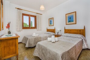 Ein Hotelzimmer mit zwei Betten, einem Schreibtisch, einer Lampe und einem Bild an der Wand.