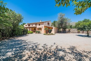 A two-story house with a patio area and a gravel driveway. - Private Pool Villa in Pollensa (Pollensa / Pollença)