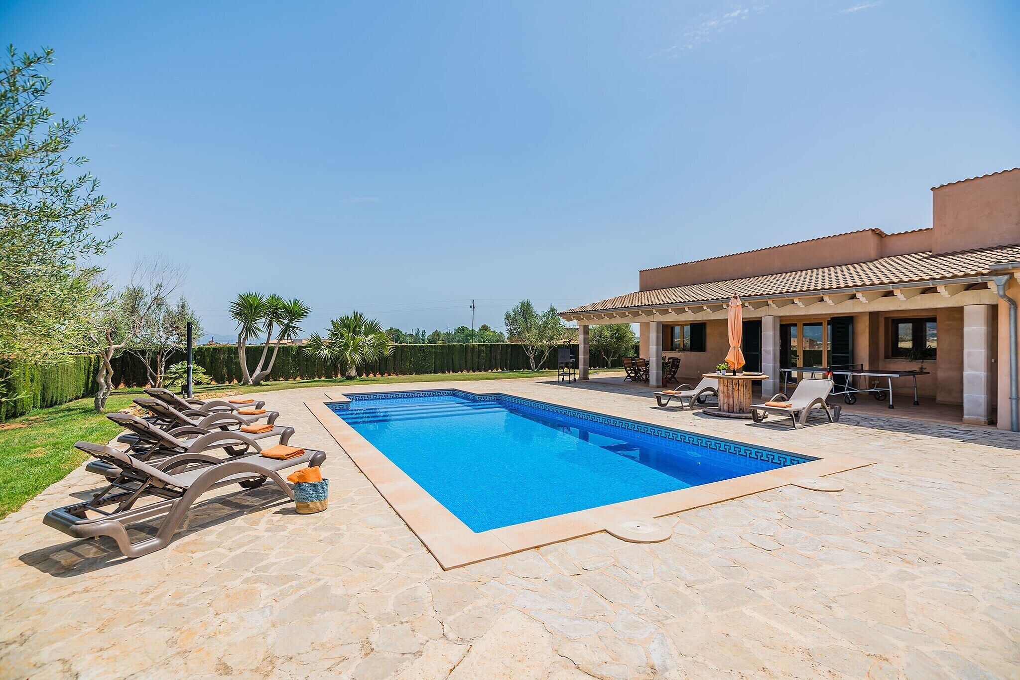 A swimming pool with lounge chairs and a covered patio area.