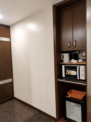 A compact kitchenette with a microwave, coffee maker, and a small refrigerator. - The Fields Palace Hotel Premier (Angeles City)