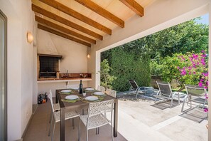 An outdoor patio with a table set for dining, a barbecue grill, and a seating area with chairs. - Central Townhouse with Pool, Pollença (Pollensa / Pollença)