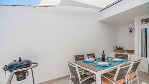 An outdoor patio with a table set for dining, a grill, and potted plants. - Pollensa Villa with Private Pool (Pollensa / Pollença)