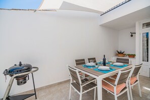 An outdoor patio with a table set for dining, a grill, and potted plants. - Pollensa Villa with Private Pool (Pollensa / Pollença)