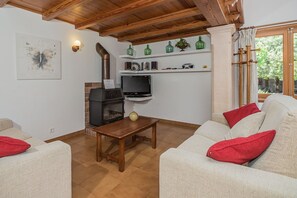 Ein Wohnzimmer mit Kamin, Fernseher und Sitzecke.