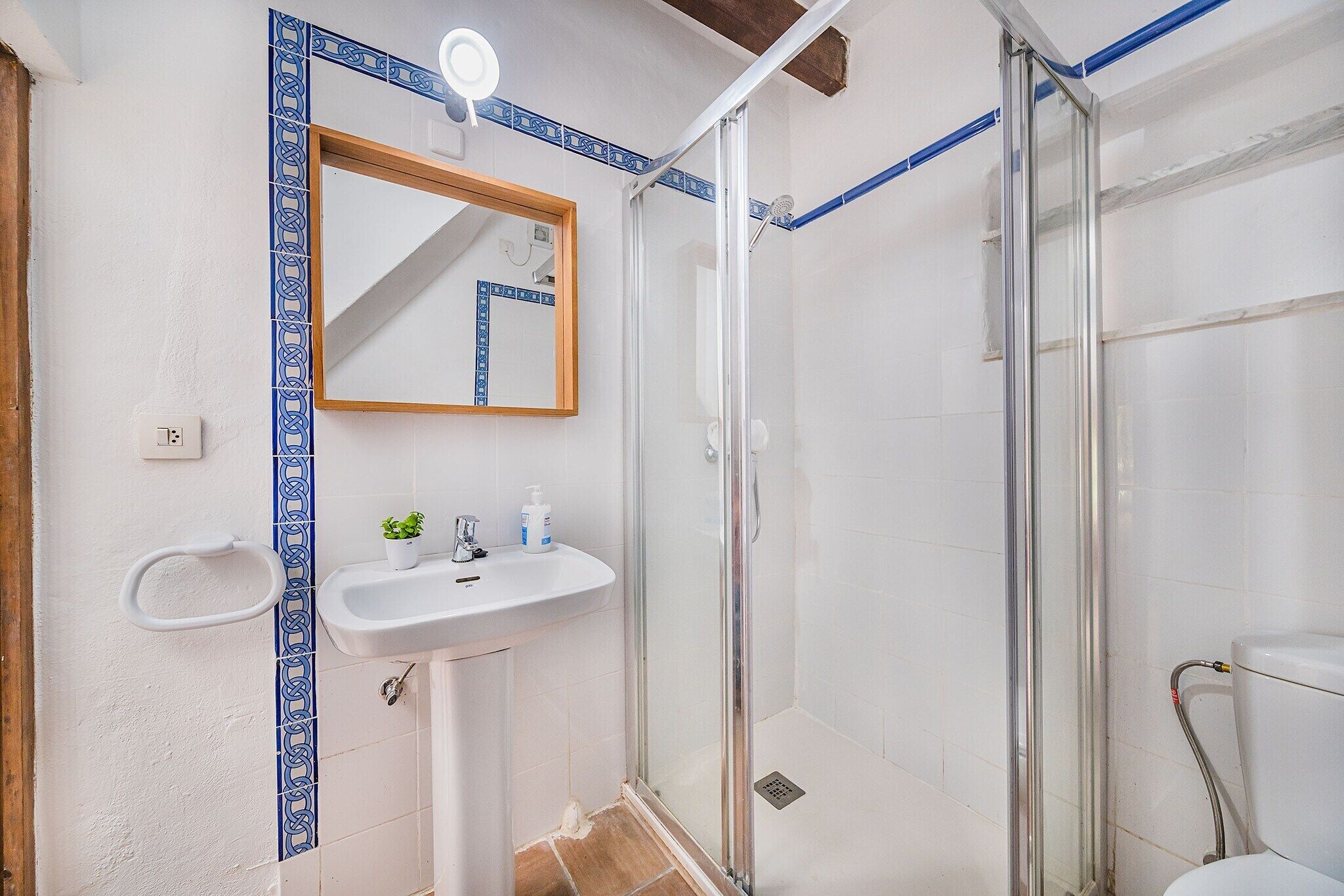 A bathroom with a shower, sink, and mirror.