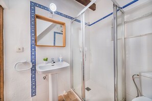 Ein Badezimmer mit Dusche, Waschbecken und Spiegel.