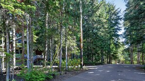 Una strada costeggiata da alberi alti e un edificio con un balcone.