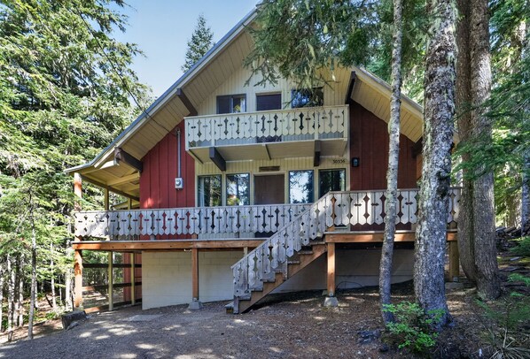 A two-story lodge with a balcony and a staircase leading to the upper level.