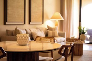 Un salon bien éclairé, avec une table ronde, un canapé et une lampe.