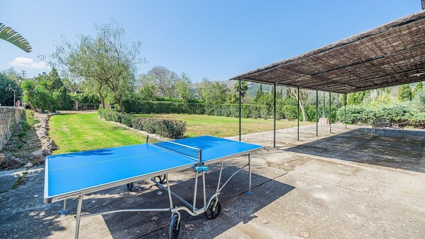 An outdoor ping pong table set up in a garden area with a pergola structure in the background. - Historic Villa with Mountain Views, Mallorca (Pollensa)