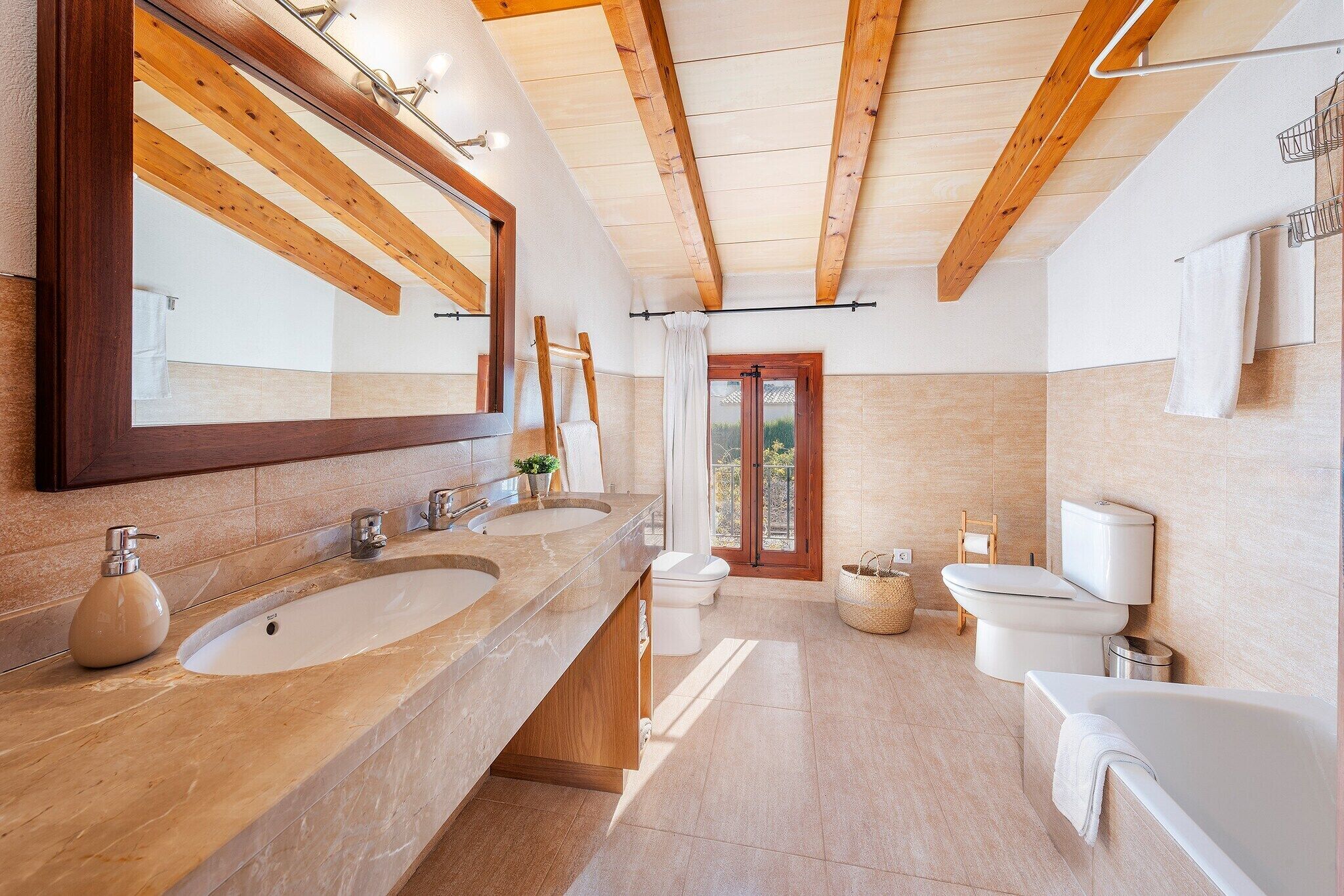 Ein modernes Badezimmer mit zwei Waschbecken, einer Badewanne und einer Toilette.