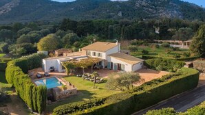 A two-story house with a swimming pool, surrounded by well-maintained gardens and a mountainous backdrop. - Villa near Pollença Town Centre (Pollensa / Pollença)