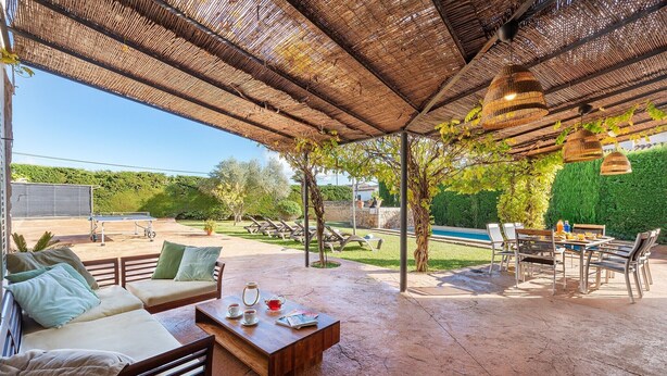 A covered outdoor seating area with a pool in the background. - Villa near Pollença Town Centre (Pollensa / Pollença)