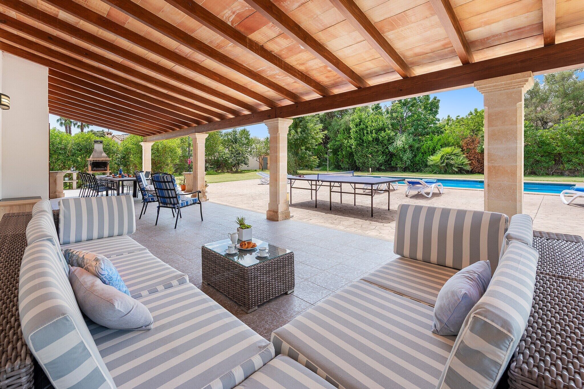 An outdoor patio with a covered seating area, a pool, and a barbecue grill.