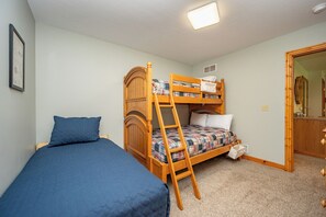 A room with a bunk bed, a single bed, a ladder, a light fixture, and a door. - New! Mountain Lake Area Getaway w/ Hot Tub! (Oakland)