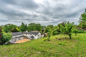 A rural landscape with houses surrounded by greenery and trees. - Romantic North Wales Meadow Cottage (Andover)