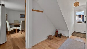 A room with a dining area, a coat rack, a fire extinguisher, and a dog. - Romantic North Wales Meadow Cottage (Andover)