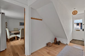 A room with a dining area, a coat rack, a fire extinguisher, and a dog. - Romantic North Wales Meadow Cottage (Andover)