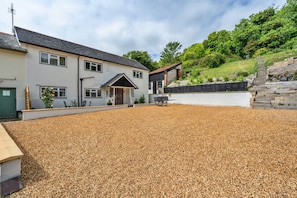 A two-story house with a gravel driveway and a stone wall. - Romantic North Wales Meadow Cottage (Andover)