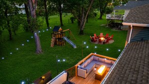 Ein Garten mit Whirlpool, einer Holz-Spielanlage und einer Sitzgruppe mit Gartenmöbeln.