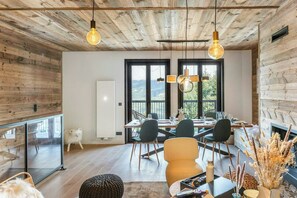 A modern dining area with a wooden ceiling, large windows, and a view of the outdoors. - Chalet-style apartment in Courchevel Village (Courchevel)