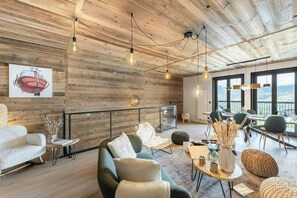 A modern interior with wooden walls, a dining area, and a view of the outdoors. - Chalet-style apartment in Courchevel Village (Courchevel)