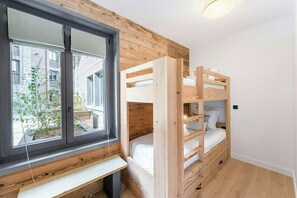 A bunk bed room with a window, wooden walls, and a bench. - Chalet-style apartment in Courchevel Village (Courchevel)
