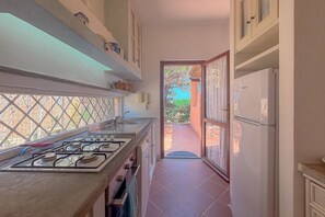 Eine Küche mit Gasherd, Schränken und einem Kühlschrank.