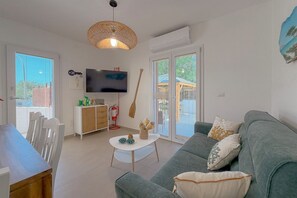 Ein modernes Wohnzimmer mit einem grauen Sofa, einem weißen Couchtisch und einem Fernseher an der Wand.
