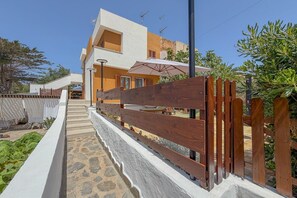 Ein mehrgeschossiges Gebäude mit einem steinernen Weg, der zu einem Holztor führt.