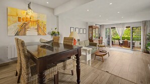 Uma sala ampla com uma mesa de jantar, cadeiras e uma pintura grande na parede.